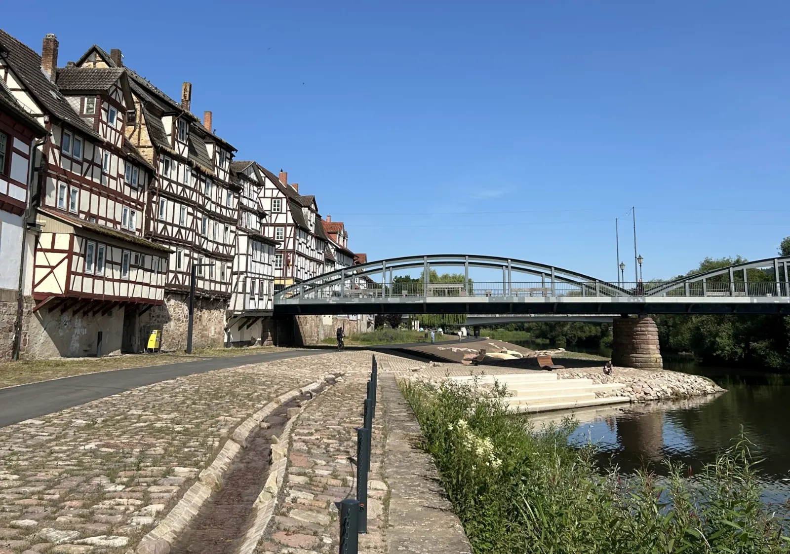 Fachwerkhäuser am Ufer der Fulda in Rotenburg, daneben die Bogenbrücke über den Fluss